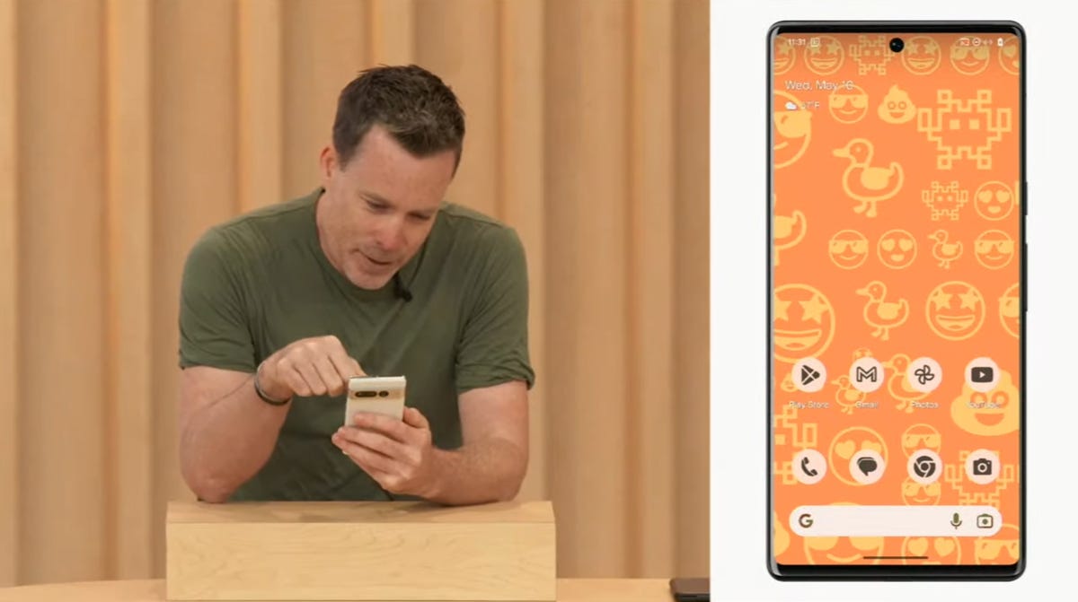 Man playing with phone, showing off emoji wallpaper